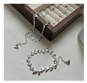 Detail of silver heart-shaped bracelet and necklace set on an elegant display