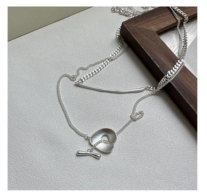 Detail of silver S925 layered necklace featuring a minimalist OT toggle clasp design