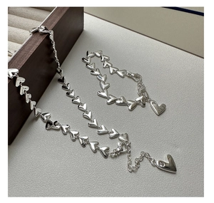 Detailed view of S925 silver heart bracelet with polished links and small zircon charms