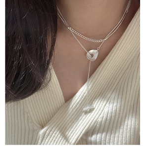 Macro detail of S925 silver Y-shaped layered necklace with brushed circle and T-bar toggle