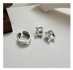 Macro shot of S925 sterling silver wide saddle earrings and double layer open ring detail