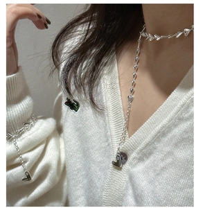 Detailed view of S925 sterling silver heart chain necklace and bracelet on model