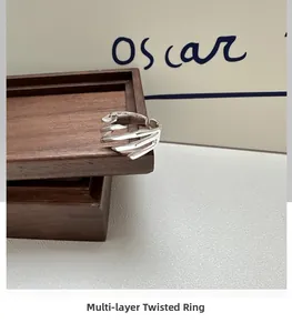 Close-up of S925 sterling silver layered cross pattern ring on a wooden box