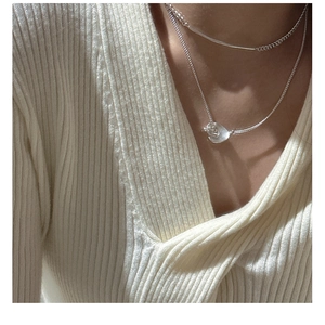 Detail of layered S925 sterling silver necklace with matte OT buckle and petal pendant
