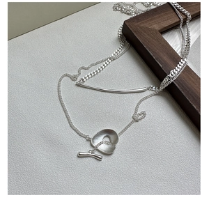Detailed macro of silver double chain necklace with heart pendant and toggle clasp