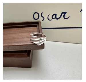 Detail of S925 sterling silver multi-layer crisscross ring on wooden jewelry box