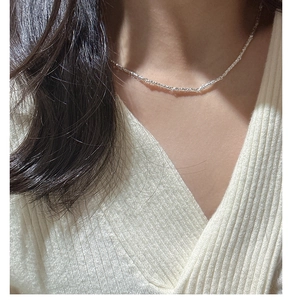 Macro shot of minimalist S925 sterling silver chain showing fine shimmering texture
