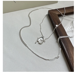 Macro shot of S925 sterling silver matte necklace with curved metal bar and organic pendant