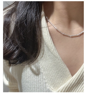Detail of S925 sterling silver textured necklace on a model with a knit sweater