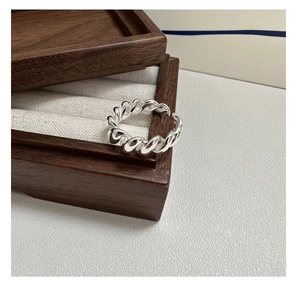 Close-up of S925 sterling silver croissant ring on a dark wooden jewelry box