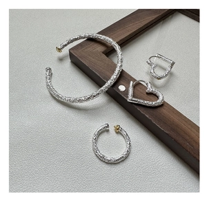 Nahaufnahme eines Vintage-Silberschmucksets mit geprägten Mustern und Goldakzenten
