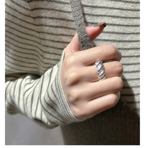 Macro detail of S925 sterling silver twisted croissant ring on a model's finger