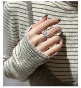 Macro view of wide S925 sterling silver twisted croissant ring on model finger