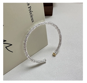 Close-up of S925 sterling silver cuff bracelet with vintage vine relief and gold accents