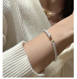 Macro detail of S925 sterling silver cuff bracelet with intricate floral scroll engraving