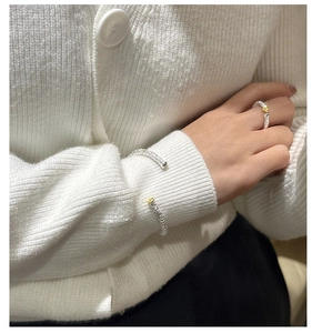 Makro-Detail von S925 Sterling Silber Hammerschlag Ring und Armband mit goldenen Blumen