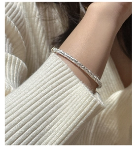 Macro detail of retro S925 sterling silver bangle featuring intricate floral relief patterns