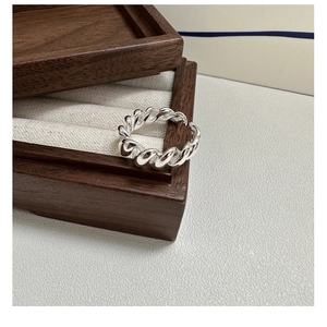 Detailed view of S925 sterling silver twisted croissant ring with polished spiral texture