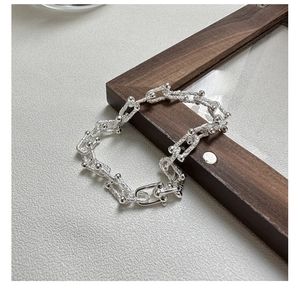 Detailed macro view of S925 sterling silver chain bracelet with U-shaped link and matte finish
