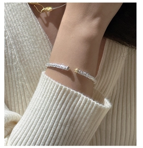 Macro shot of S925 sterling silver cuff bracelet with gold accents and relief texture