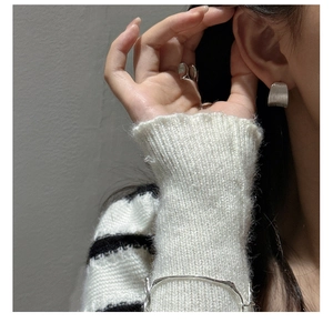 Close-up of minimalist silver earrings and ring set with matte textured silver bracelet