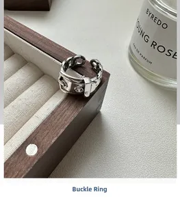 Close-up of S925 sterling silver belt buckle ring on a luxury wooden jewelry box