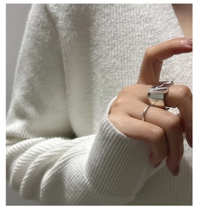 Close-up of S925 sterling silver wrinkled wave and minimalist smooth rings on finger