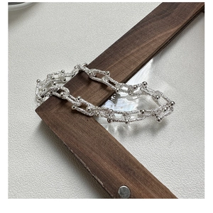Macro detail of S925 sterling silver U-shaped link bracelet with textured ball accents
