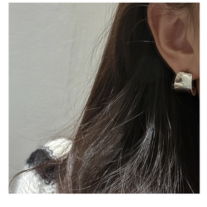 Close-up of minimalist S925 sterling silver C-shaped polished stud earrings on model