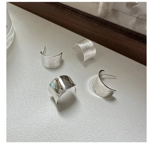 Close-up of S925 sterling silver earrings featuring brushed and polished finishes