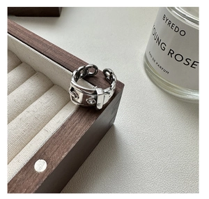 Close-up of S925 sterling silver belt buckle ring on a luxury wooden jewelry box