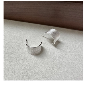 Close-up of S925 sterling silver C-shaped stud earrings with a brushed matte finish