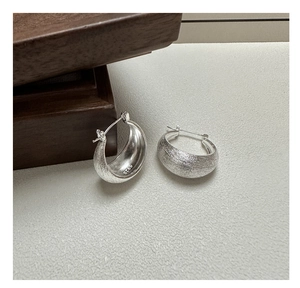 Detailed macro view of S925 sterling silver hoop earrings with a brushed matte texture