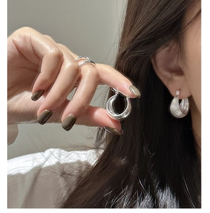 Close-up of S925 silver chunky teardrop earrings and a minimalist ring on a model