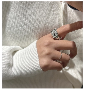 Detail of S925 silver belt buckle ring set styled with a cozy white knit sweater