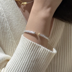 S925 sterling silver open bangle with lava texture and golden beads worn on wrist