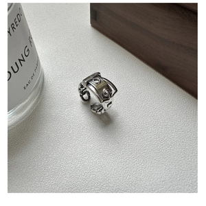 Detailed view of silver belt buckle ring with vintage texture on a grey surface