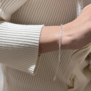 Bracelet barre minimaliste en argent massif S925 au poignet sur un pull en maille douce