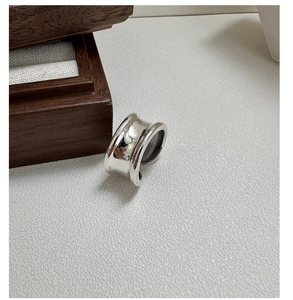 Close-up of minimalist S925 sterling silver wide concave ring with high-gloss finish