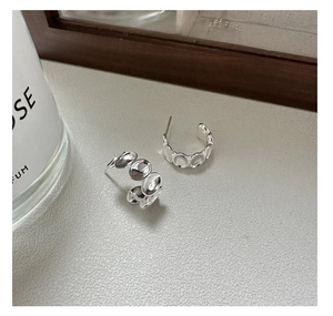 Detailaufnahme der S925 Sterlingsilber C-Ohrringe mit industrieller Scheibenstruktur