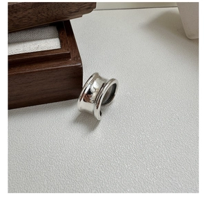 Macro shot of minimalist silver concave ring on a wooden jewelry box