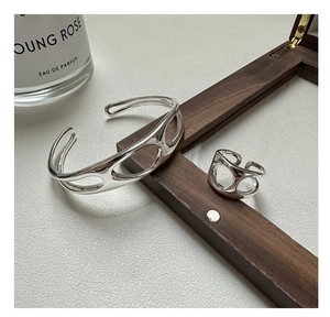 Detailed view of polished S925 sterling silver hollow ring and matching cuff bracelet set