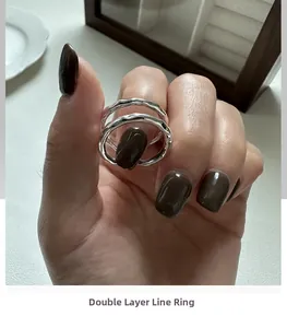 Primo piano di un anello d'argento a doppio strato ondulato con texture di metallo fluido
