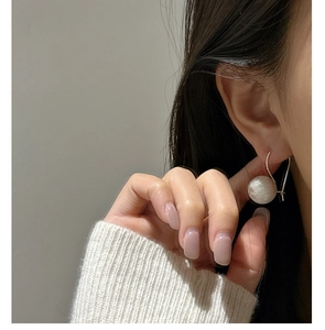 Detail of minimalist S925 sterling silver ball earring with brushed matte texture on ear
