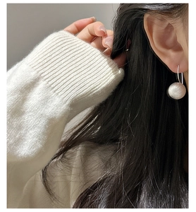 Detail of S925 sterling silver ball drop earring with a matte brushed texture on ear