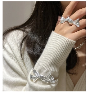 Close-up of S925 silver butterfly knot ring and matching bracelet on a model