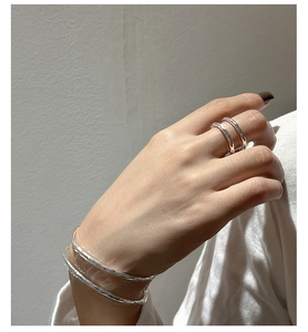Primo piano dell'anello a doppio strato in argento S925 e bracciale testurizzato