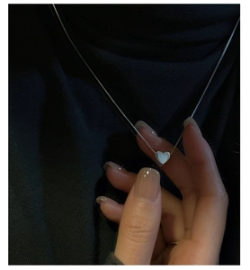 Collier avec pendentif cœur en argent minimaliste et chaîne box sur fond de tissu noir