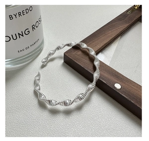 Macro view of S925 sterling silver bangle featuring a twisted DNA helix wave texture