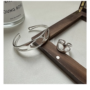 Macro view of S925 sterling silver hollow geometric ring and bracelet set with metallic shine